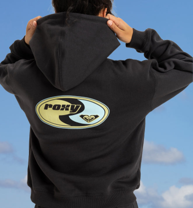 Back view of a woman wearing a black hoodie with Roxy on it, ideal for casual outings or lounging around home